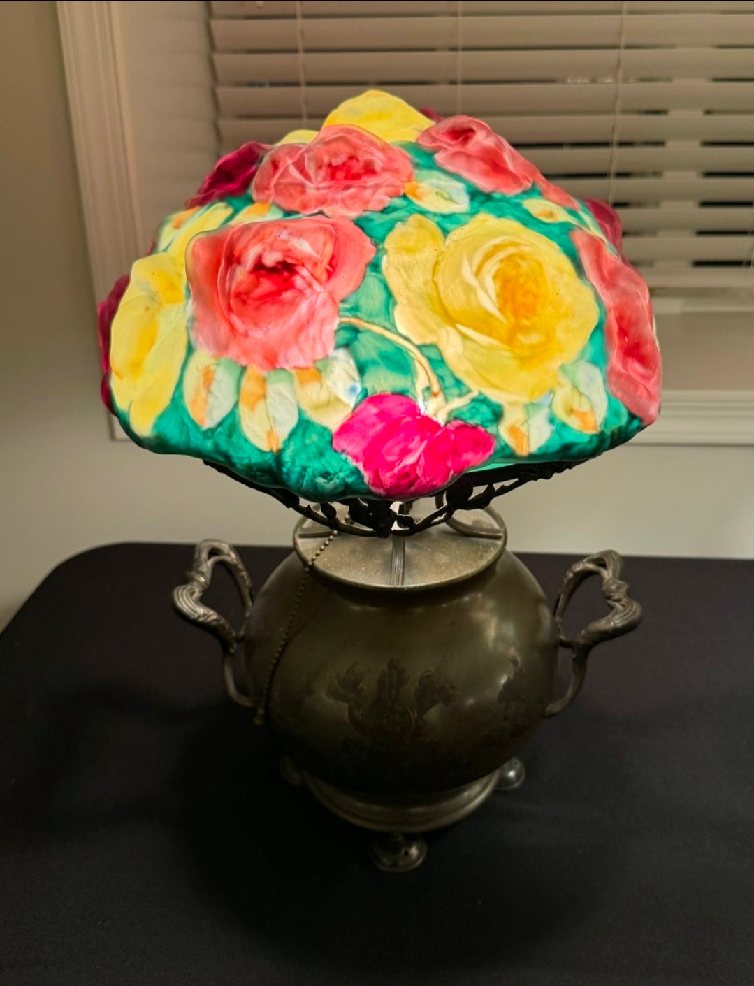 Decorative lamp with floral shade on a dark surface