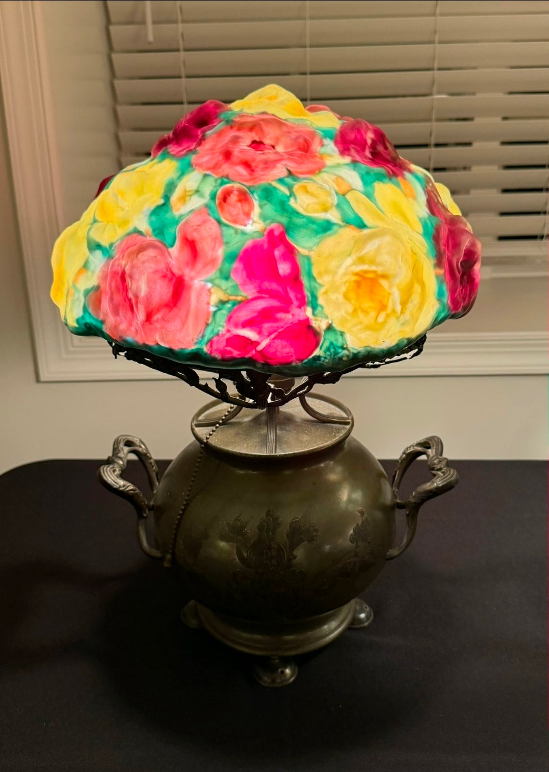 Decorative lamp with a colorful floral shade on a dark surface.