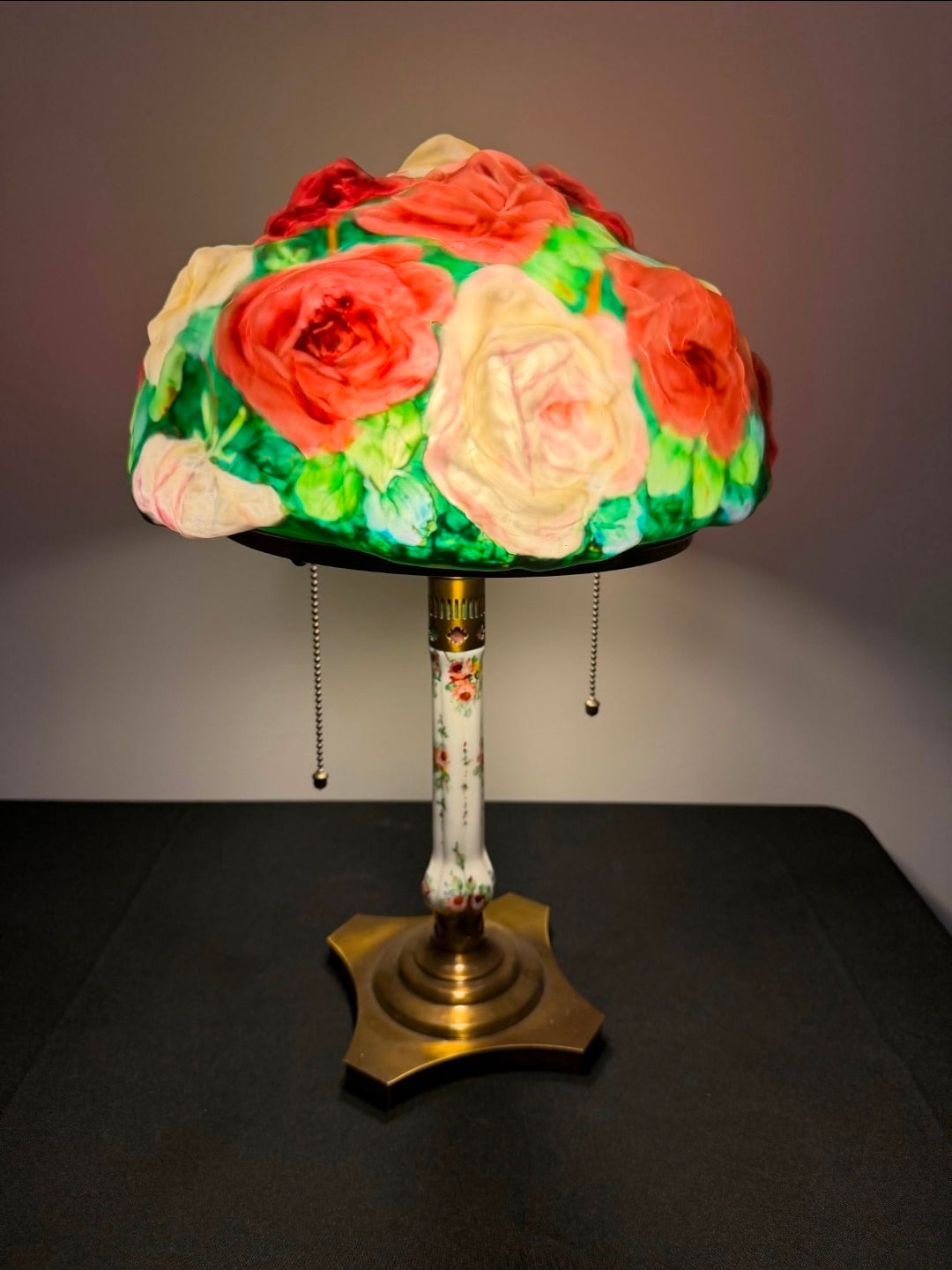 Decorative lamp with floral shade on a dark surface