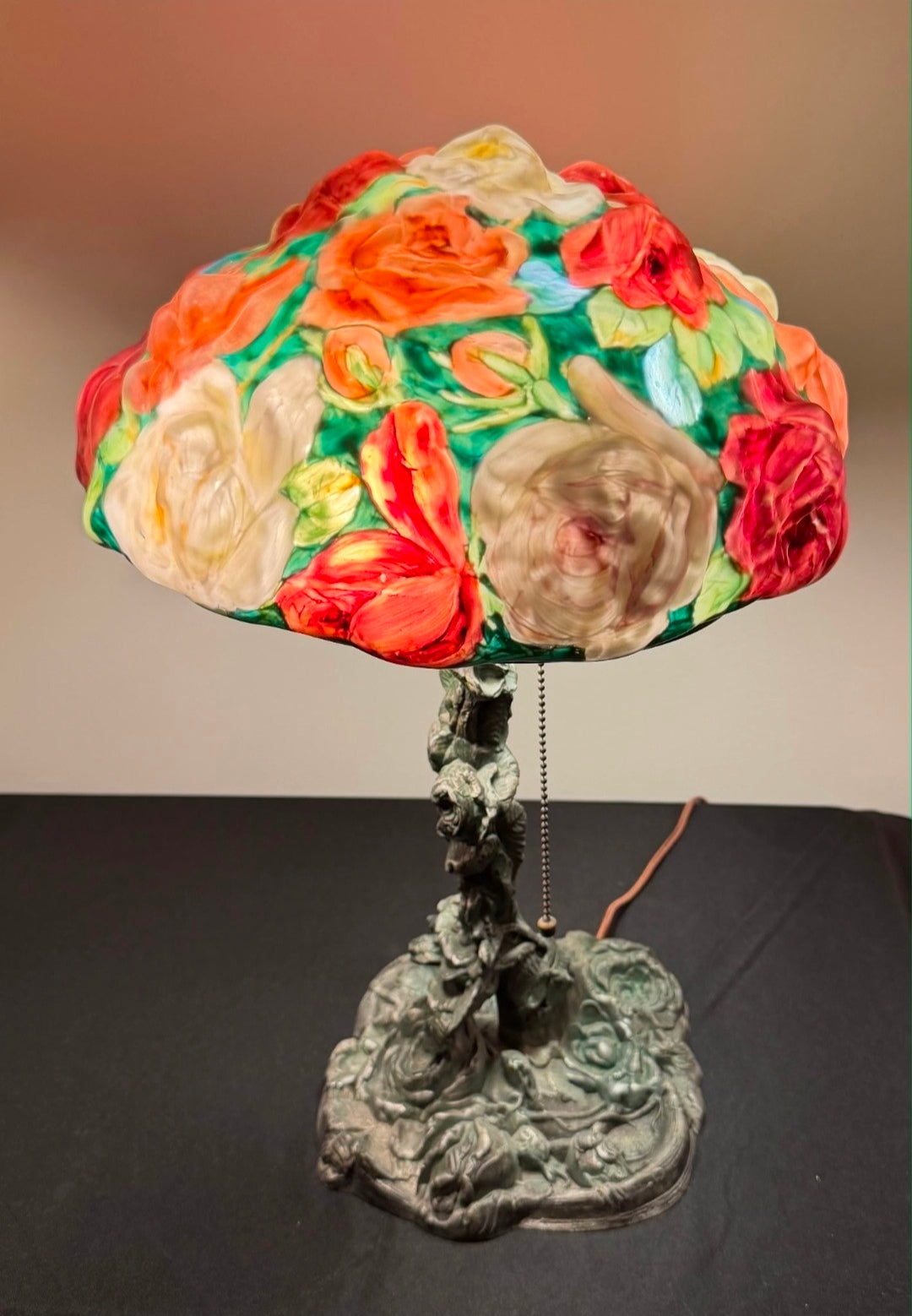 Decorative lamp with a colorful floral shade on a dark surface